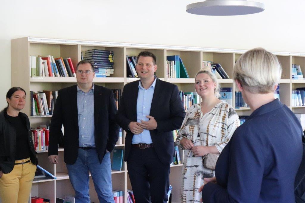 In der Bibliothek des Bildungsinstituts sprechen fünf Abgesandte der Partnerinstitutionen über die Internationale Pflegeschule