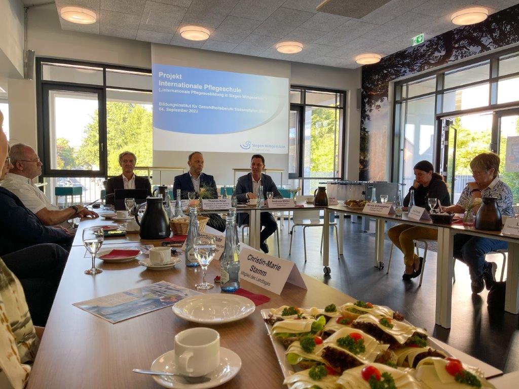 Im Besprechungsraum des Bildungsinstituts wird über die Internationale Pflegeschule gesprochen